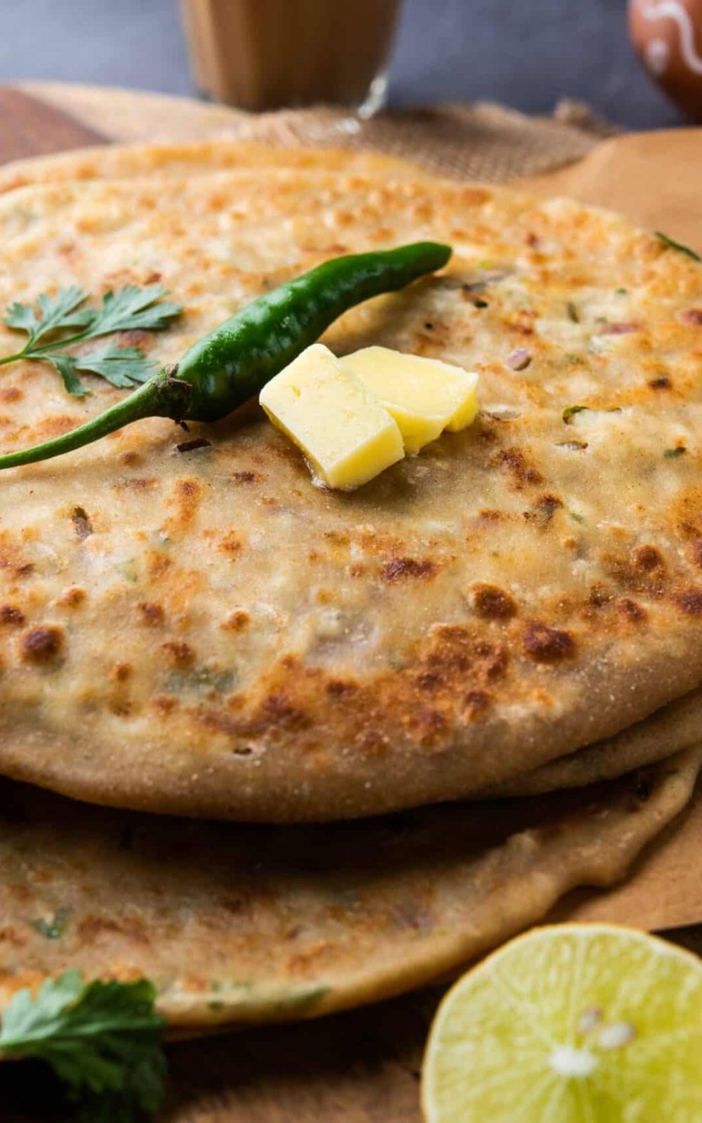 Paneer paratha is a popular North Indian flatbread made with whole wheat flour dough and stuffed with savory, spiced, grated paneer
